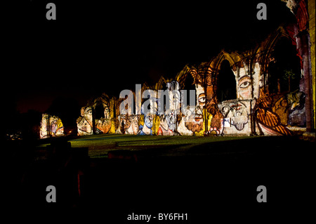 Opere d'arte medievali proiettate sulle rovine dell'Abbazia di Santa Maria di notte. Foto Stock