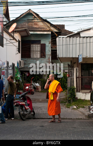 Monaco sulla strada a parlare sul suo cellulare, Chiang Mai, Thailandia Foto Stock