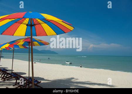 Malaysia, Isola di Penang, Golden Sands Beach Resort. Spiaggia privata con ombrelloni colorati. Foto Stock