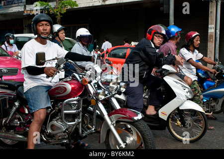 Persone su motocicli in attesa ad un semaforo, Bangkok, Thailandia Foto Stock