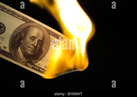 Immagine di un centinaio di bill masterizzazione su sfondo nero Foto Stock