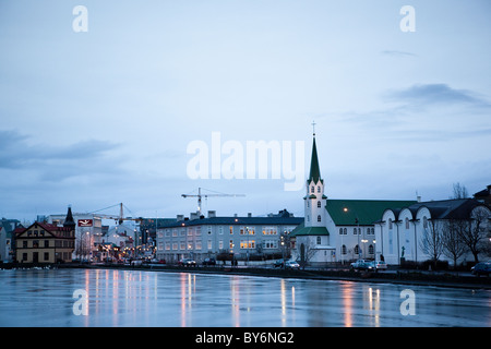 Edifici lungo il laghetto congelato (Tjörnin) nel centro di Reykjavík, Islanda. Foto Stock