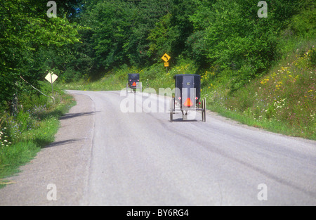 Amish buggies viaggiando su strada giù in Pennsylvania Foto Stock