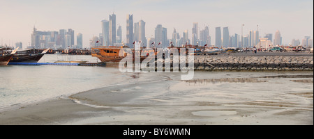 Una vista della skyline di Doha attraverso il porto Dhow a bassa marea Foto Stock