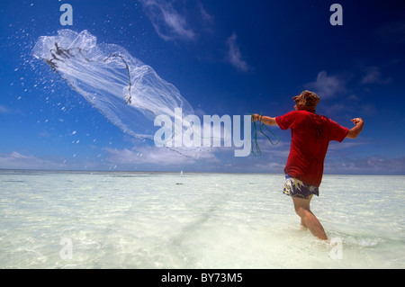 Man throwing castnet in shallow tropical waters, North West Island, Great Barrier Reef Marine Park, Queensland, Australia. No MR Foto Stock