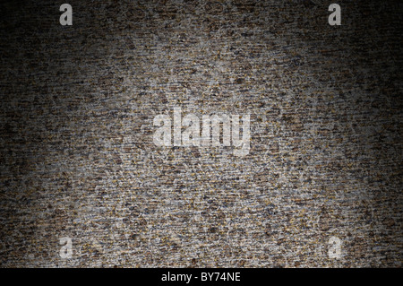 Primo piano della roccia grigio superficie texture drammaticamente illuminati dal di sopra Foto Stock