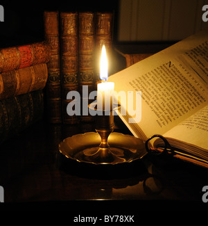 Libri antiquario illuminato a lume di candela Foto Stock