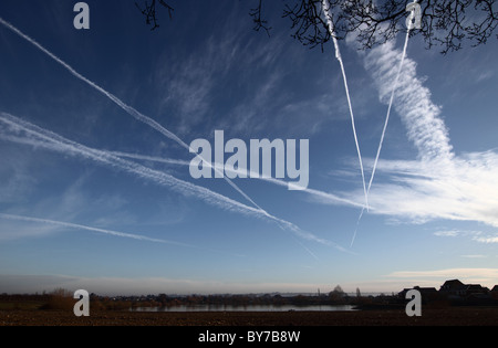 I contrails o i percorsi del vapore sono sentieri di condensazione e nuvole di cirrus artificiali, cielo blu sopra il Lincolnshire, percorsi multipli. Foto Stock