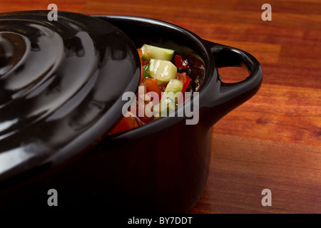 Salsa piccante in piccoli ghisa nera che serve pot. Foto Stock