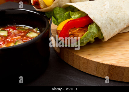 Pollo speziato wrap e pot di vibranti di salsa. Foto Stock