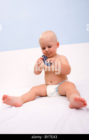 Baby boy, 1 anno, con telefono mobile Foto Stock