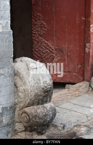 Il tamburo a forma di pietra della porta nella parte anteriore di un ingresso rosso Foto Stock