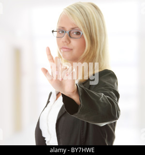 Bella giovane imprenditrice rendendo scelta su screan astratto Foto Stock