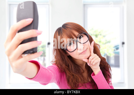 Giovane donna asiatica scatta una foto con il suo telefono cellulare Foto Stock