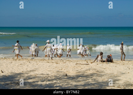 Malindi Marine Park in Kenya con bambini che giocano in mare nelle loro uniformi scolastiche Foto Stock