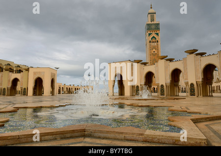 Minareto e fontane presso la moschea di Hassan II a Casablanca in Marocco in un giorno di tempesta Foto Stock