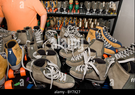 Pattini a rotelle impilati su un contatore a rullo rink, per uso di noleggio Foto Stock