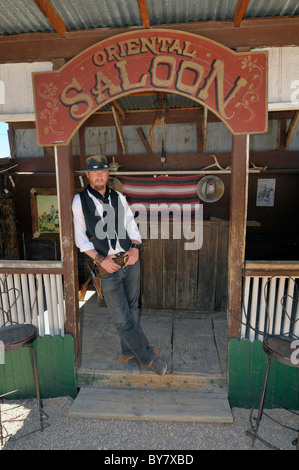 Pistolero con la pistola e la custodia nella parte anteriore del saloon Tombstone Arizona Foto Stock