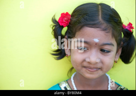 Abbastanza felice giovani villaggio indiano il ritratto di Ragazza con rose tra i capelli. Andhra Pradesh, India. Messa a fuoco selettiva con copia spazio. Foto Stock