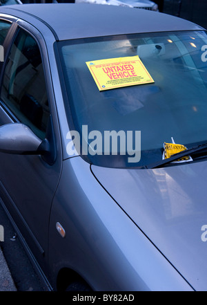 Permessi non tassati adesivo di avvertenza attaccato al parabrezza del veicolo attenzione a non spostare il veicolo bloccato regno unito Foto Stock