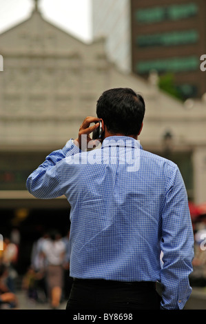 L'uomo facendo chiamata con il Cellulare Raffles Place Singapore Foto Stock