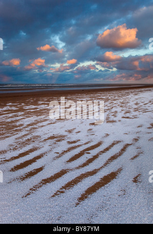 Neve che ricoprono le dune di sabbia e spiaggia a Holkham Bay sulla costa di Norfolk in inverno Foto Stock