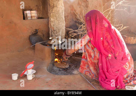 India Rajasthan, Jodhpur, donna in abito tradizionale di roti di cottura (noto anche come chapati) sul fuoco aperto Foto Stock