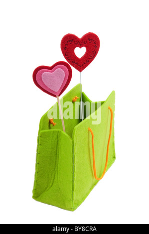 Due cuori rossi su bastoni in un verde presente in borsa Foto Stock