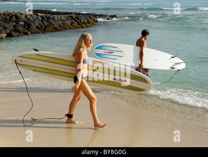 Giovane donna andando surf sulla spiaggia di Waikiki Hawaii Honolulu Oahu Oceano Pacifico Foto Stock