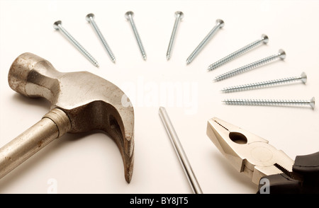 Il martello, le pinze, il cacciavite e viti disposte. Girato su uno sfondo bianco. Foto Stock