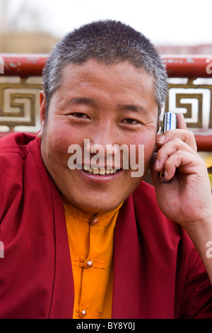 Monaco tibetano parlando al cellulare in Piazza Barkhor, Lhasa, in Tibet. JMH4451 Foto Stock