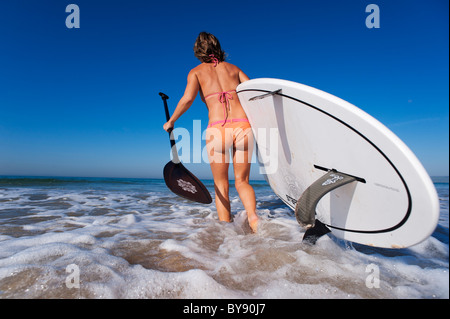 Donna di andare in mare con una pagaia board Foto Stock