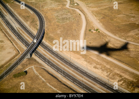 Forme di viaggio o di viaggio concetto - ombra di un aereo in volo su una grande autostrada, superstrada, autostrada Foto Stock