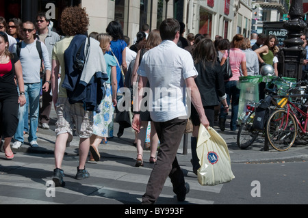 Parigi, Francia, Crowd Walking, Scene of People Shopping, su 'Rue de Rivoli', scena di strada occupata, a piedi, negozi, centro di strada; uomo con borse per la spesa Foto Stock