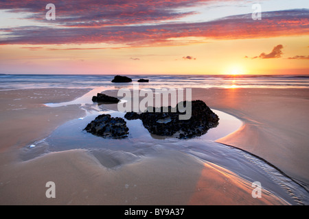 Una serata estati a Bedruthan Steps. La bassa marea rivela le rocce coperte con le cozze Foto Stock