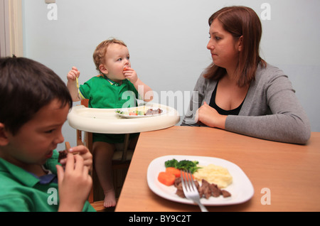 Madre Single a cena con i suoi due figli piccoli. Foto Stock