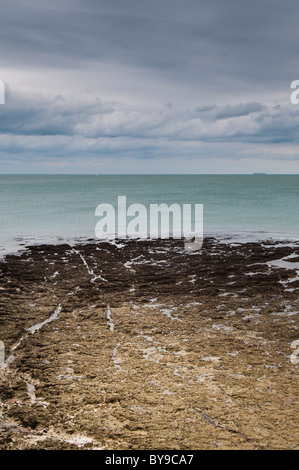 Mare calmo con rocce su foreshore Foto Stock