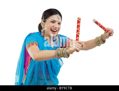 Gujarati donna con bastoni dandiya Foto Stock