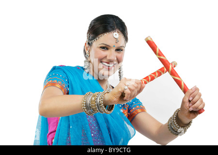 Gujarati donna con bastoni dandiya Foto Stock