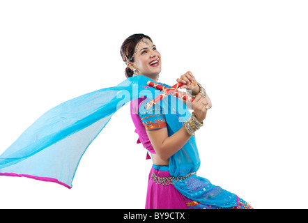 Gujarati woman dancing con bastoni dandiya Foto Stock