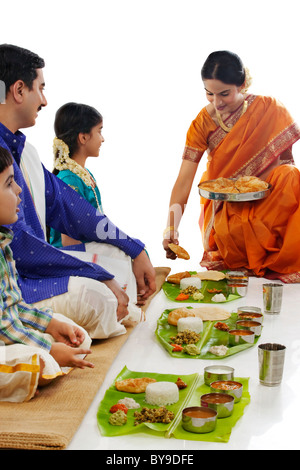 Sud donna indiana di servire il cibo alla sua famiglia Foto Stock