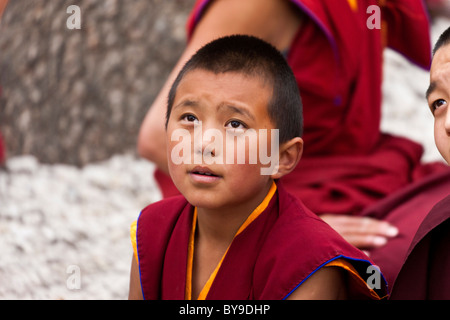 Ragazzo giovane monaco discutendo cortile al Monastero di Sera Lhasa il Tibet. JMH4609 Foto Stock