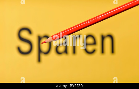 Matita rossa nella parte anteriore del fuori fuoco parola Sparen, tedesco per il salvataggio Foto Stock