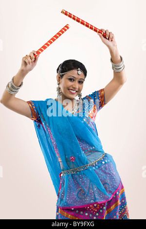 Gujarati donna con bastoni dandiya Foto Stock