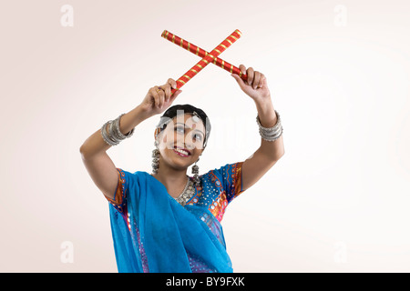 Gujarati donna con bastoni dandiya Foto Stock