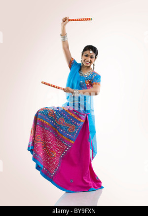 Gujarati donna con bastoni dandiya Foto Stock