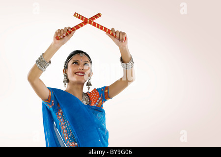 Gujarati donna eseguendo dandiya Foto Stock