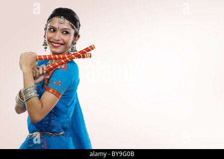 Gujarati donna eseguendo dandiya Foto Stock