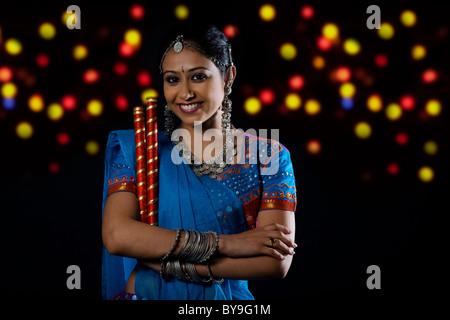 Gujarati donna con bastoni dandiya Foto Stock