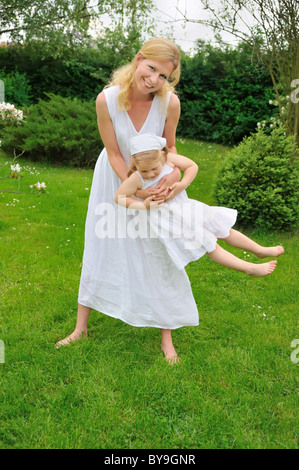 Felice giovane madre e figlia giocando in Prato Foto Stock